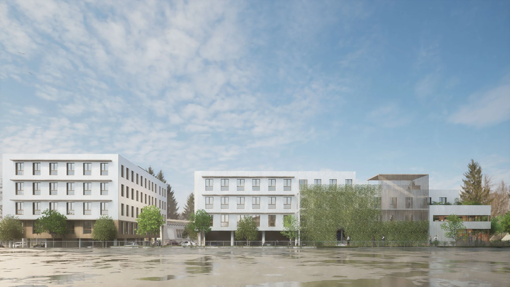 Façade de l'immeuble de bureau sur pilotis avec le parking, on voit sur le bâtiment de la peinture blanche avec un bardage en bois clair.